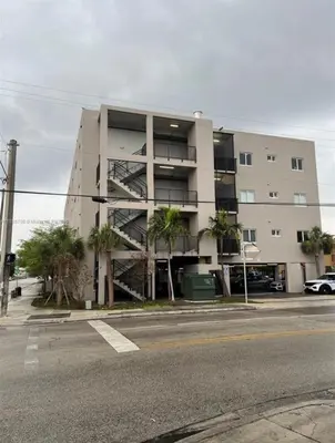 an apartment building with palm trees in front of it at Spacious 3BR-2BA Apt near Downtown-Miami Airport in Miami