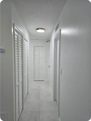 a hallway with white walls and a white door at Chacon in Miami