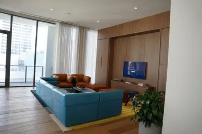 a living room with a blue couch and a table at Stylish Minimalist 1BR in The Crosby in Miami
