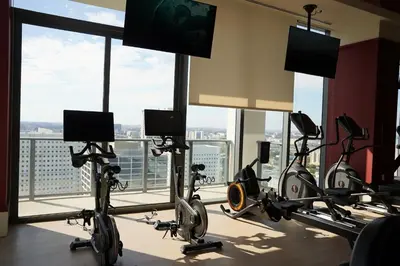 a gym with treadmills and bikes in a room with windows at Stylish Minimalist 1BR in The Crosby in Miami