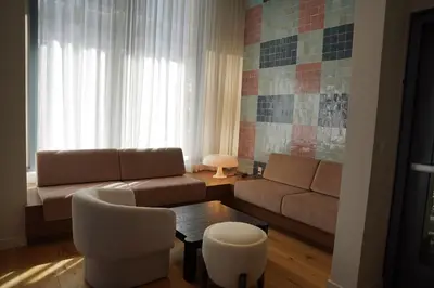 a living room with a couch and a table and chairs at Stylish Minimalist 1BR in The Crosby in Miami