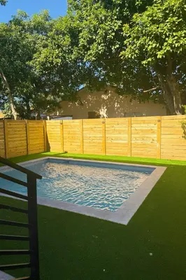 a swimming pool in a yard with a wooden fence at Art District Stay Wynwood & Design District Nearby in Miami