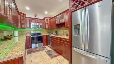a kitchen with wooden cabinets and a stainless steel refrigerator at Modern & Central Miami Free Parking & WiFi in Miami