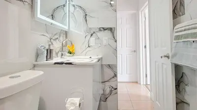 a white bathroom with a sink and a mirror at Modern & Central Miami Free Parking & WiFi in Miami