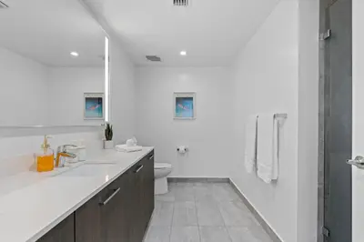 a white bathroom with a sink and a toilet at The Downtown Miami 2BR 2BA Luxury Stay in Miami