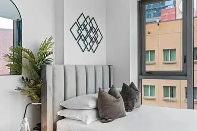 a white couch with pillows in a room with a window at The Downtown Miami 2BR 2BA Luxury Stay in Miami
