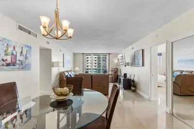 a dining room and living room with a glass table at Oceanfront Condo with Direct Beach Access in Hollywood Beach