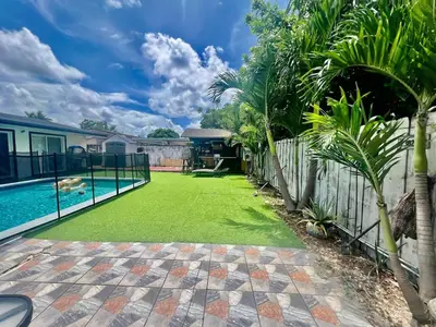 a yard with a pool and a fence and trees at Better Experience Property in Miramar