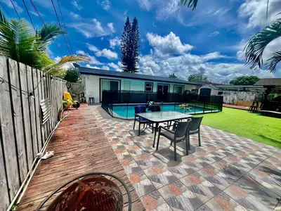 a patio with a table and a swimming pool at Better Experience Property in Miramar
