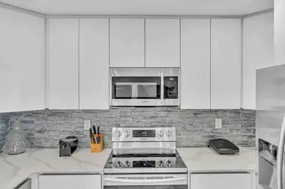 a white kitchen with a stove and a microwave at Waterfront ocean House Hollywood Hard Rock airport in Fort Lauderdale