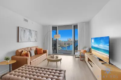 a living room with a couch and a tv at Beachwalk Condo in Hallandale Beach