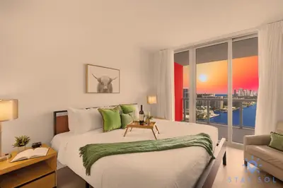 a bedroom with a large bed and a window at Beachwalk Condo in Hallandale Beach