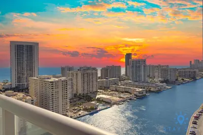 a view of a city at sunset from a balcony at Beachwalk Condo in Hallandale Beach