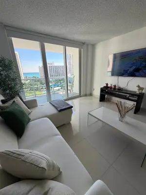a living room with a white couch and a large window at Exceptional apartment in Sunny Isles in Sunny Isles Beach
