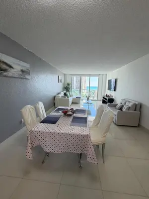 a dining room with a table and chairs and a living room at Exceptional apartment in Sunny Isles in Sunny Isles Beach