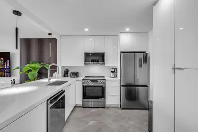 a kitchen with white cabinets and stainless steel appliances at Huge Balcony Oceanfront 2 Bedrooms with Free Parking in Miami Beach