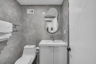 a bathroom with a toilet and a sink and a mirror at Huge Balcony Oceanfront 2 Bedrooms with Free Parking in Miami Beach