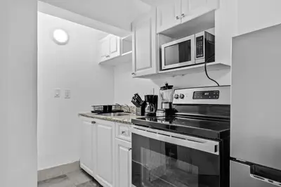 a kitchen with white cabinets and a stove top oven at Cozy Studio 2 Blocks from the Beach - Unit #3 in Hollywood