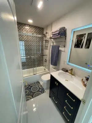 a bathroom with a sink and a toilet and a mirror at Spanish Style home in Miami Upper East Side in Miami