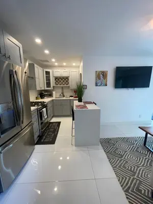 a kitchen with white cabinets and stainless steel appliances at Spanish Style home in Miami Upper East Side in Miami