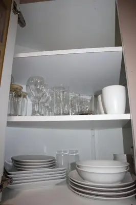 a white cabinet with plates and glasses in it at Modern house with pool close to HARD ROCK in Pembroke Pines