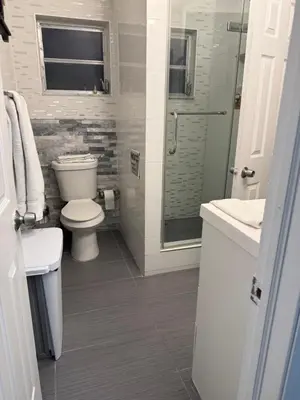 a white bathroom with a toilet and a shower at My Help Comes from The Lord Miami in Palmetto Bay