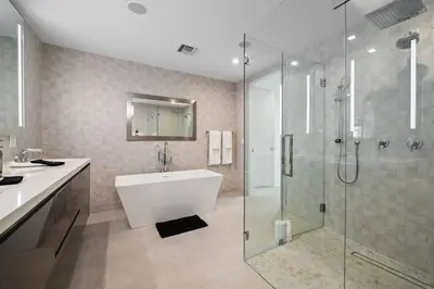 a bathroom with a tub and a glass shower at Las Olas Villa in Fort Lauderdale