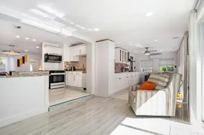 a living room with a couch and a kitchen at Tropical Retreat- Heated Pool 3 Miles to the Beach in Fort Lauderdale