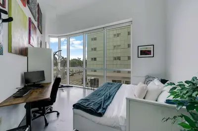 a bedroom with a bed and a desk with a computer at The Vizcayne Vibe- Sauna Pool and Sundeck in Miami