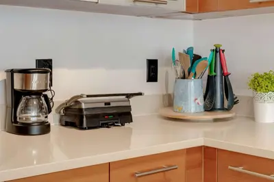 a kitchen counter with a coffee maker and utensils at Midtown Rouge- Condo with City Views Pool & Gym in Miami
