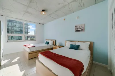 a bedroom with two beds and a window at Midtown Rouge- Condo with City Views Pool & Gym in Miami