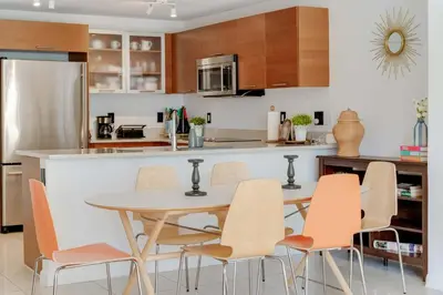 a kitchen with a table and chairs in a kitchen at Midtown Rouge- Condo with City Views Pool & Gym in Miami