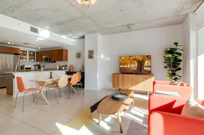 a kitchen and living room with a table and chairs at Midtown Rouge- Condo with City Views Pool & Gym in Miami