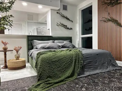 a bedroom with a bed with a green blanket at Tropical Nest Residence in Hollywood