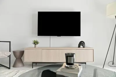 a living room with a tv on a white wall at Pool & Gym | King Bed | Downtown Hollywood in Hollywood