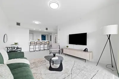 a living room with a couch and a tv at Pool & Gym | King Bed | Downtown Hollywood in Hollywood