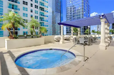 a hot tub on a patio with a view of buildings at Sky-High Urban Sanctuary with Coastal Glimpses in Miami