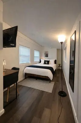 a bedroom with a bed and a desk and a television at Ariia Fort Lauderdale Airport in Fort Lauderdale