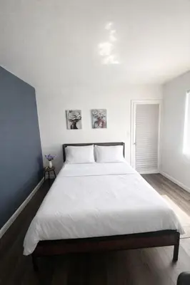 a bedroom with a large bed with white sheets at Ariia Fort Lauderdale Airport in Fort Lauderdale
