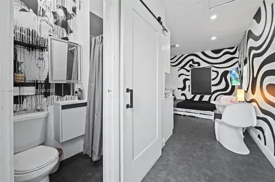 a bathroom with a toilet and a tv on a wall at Studio in Design District in Miami