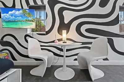 a table and chairs in a room with a wall at Studio in Design District in Miami