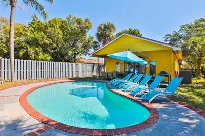 a swimming pool with chairs and a house at Zero Mile Villa Start your journey in Hollywood