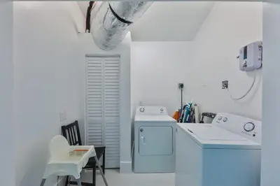 a white kitchen with a washing machine and a sink at Zero Mile Villa Start your journey in Hollywood