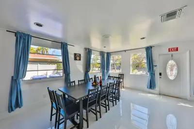 a dining room with blue curtains and a table and chairs at Zero Mile Villa Start your journey in Hollywood