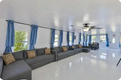 a living room with a couch and blue curtains at Zero Mile Villa Start your journey in Hollywood