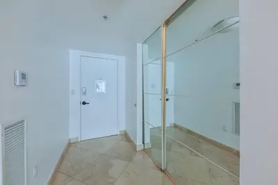 a glass elevator in a white room with a door at Blue Horizon at Sunny Isles King David in Sunny Isles Beach