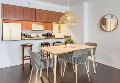 a kitchen and dining room with a wooden table and chairs at Prime Brickell Stay with Pool Gym & Parking in Miami