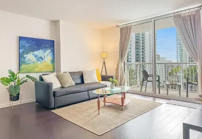a living room with a couch and a large window at Prime Brickell Stay with Pool Gym & Parking in Miami