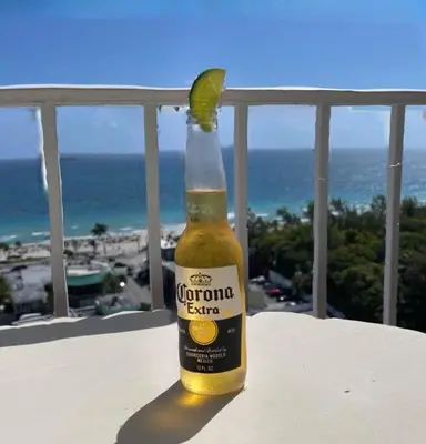 a bottle of corona beer with a lime on a balcony at 2 BR-11th Floor Corner Unit - Fort Lauderdale Beach Resort in Fort Lauderdale