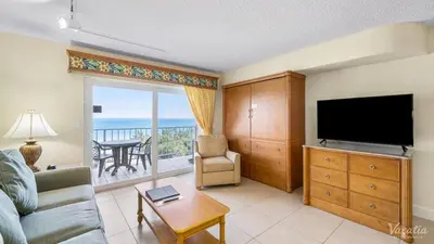 a living room with a couch and a television and a balcony at 2 BR-11th Floor Corner Unit - Fort Lauderdale Beach Resort in Fort Lauderdale